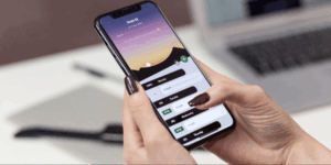 女性がスマートフォンを手に持ち、ヘルスケアアプリの週間スケジュールと進捗状況を確認している様子。デジタルツールによる健康管理のイメージ。