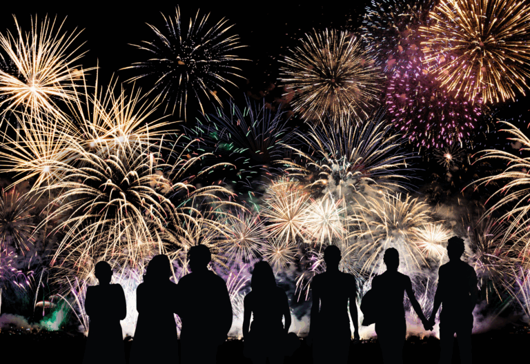 Japanese fireworks festival at night, with silhouettes of people watching colorful bursts over a river — a shared cultural UX experience of awe and reflection.