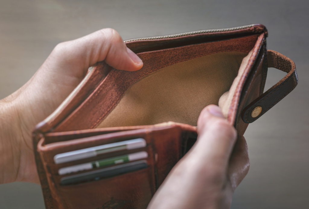 A person holds open an empty leather wallet, symbolizing the decline of physical money. This image reflects a core finding of our UX research: how the cashless shift in Japan is changing user behavior and making traditional tools obsolete.
