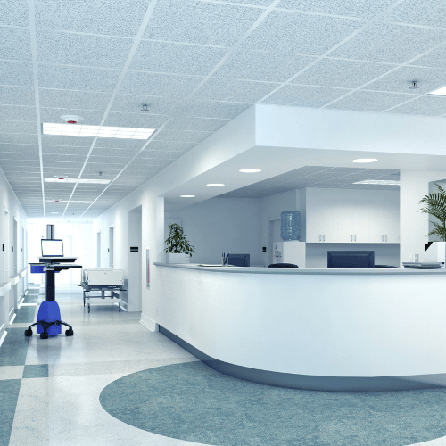 人影のない病院のナースステーションと廊下。医療カートやストレッチャーが置かれている。アジアにおける医療機器のHFE（ヒューマンファクターズエンジニアリング）評価では、このような調査環境の確保や医療機関との調整が重要となることを象徴している。