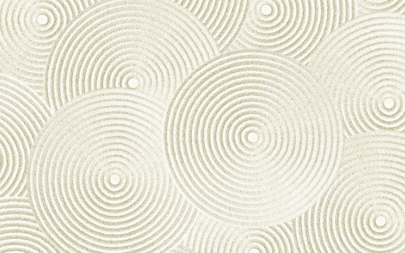 An overhead view of overlapping concentric circles drawn in sand. The deliberate and repeating pattern visually represents 'style' and choosing items that match a consistent aesthetic.